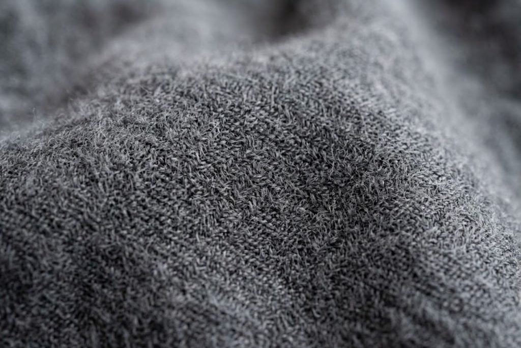 Close-up texture of hi-tech cashmere fabric showing soft plush surface and weave pattern