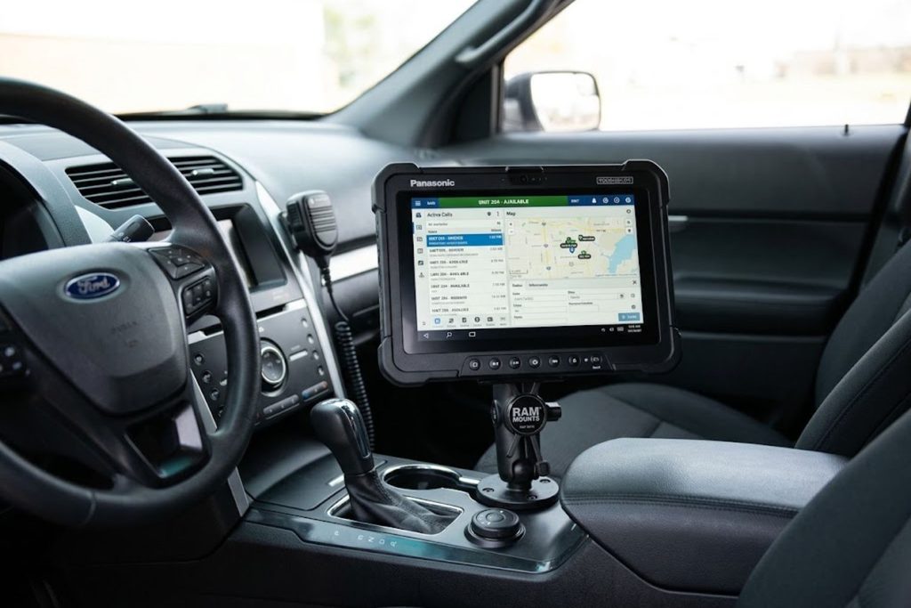 Mobile Data Terminal mounted in police vehicle showing touchscreen interface for accessing law enforcement databases